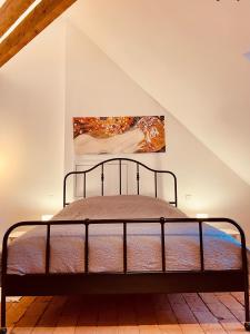 a bedroom with a metal bed in a attic at Studio Hyper-Centre Villa Isabelle in Allevard