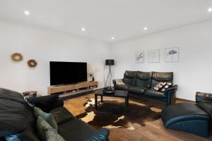 a living room with a couch and a flat screen tv at Ferienwohnung Spanier in Pouch