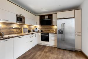 a kitchen with white cabinets and stainless steel appliances at Ferienwohnung Spanier in Pouch
