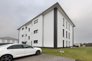 a white car parked in front of a white building at Ferienwohnung Spanier in Pouch