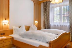 a bedroom with two beds with white pillows and a window at Mayr Apartments Zwei in Plaus