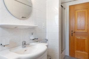 a white bathroom with a sink and a mirror at Mayr Apartments Zwei in Plaus +20 photos