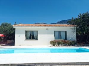 a villa with a swimming pool in front of a house at Villa Kochilaki Ideales Resort in Kefallonia