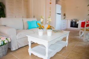 a living room with a white couch and a table at Villa Kochilaki Ideales Resort in Kefallonia +10 photos