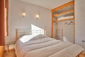 a bedroom with a large bed with white sheets at Les Airelles in Chamrousse