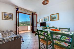 a living room with a table and chairs with a view at Appartamenti Bonalaccia in Campo nell'Elba