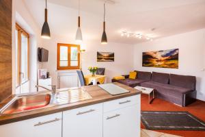 a kitchen and living room with a couch at Gästehaus Wolfgang Weitsee in Ruhpolding