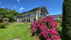 a building with pink flowers in the yard at Gästehaus Wolfgang Weitsee in Ruhpolding