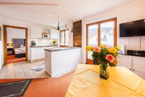 a kitchen with a table with a vase of flowers on it at Gästehaus Wolfgang Weitsee in Ruhpolding
