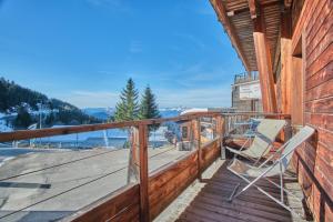 a wooden deck with a chair on it at Les Airelles in Chamrousse