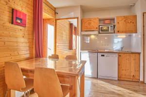 a kitchen with a table and chairs in a room at Les Airelles in Chamrousse