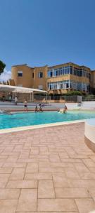 a swimming pool with people in the water at Studio Flat Blu Palermo Mondello in Palermo