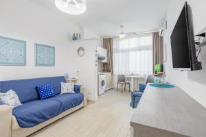 a living room with a blue couch and a kitchen at Studio Flat Blu Palermo Mondello in Palermo