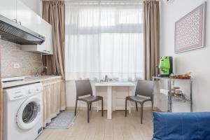 a kitchen with a washing machine and a table and chairs at Studio Flat Blu Palermo Mondello in Palermo