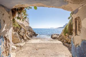 a stone path leading to the ocean through a window at Studio Flat Blu Palermo Mondello in Palermo