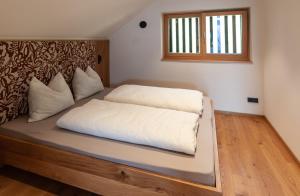 a bed with white sheets and a window in a room at Hofer Hof Spieler in Lagundo
