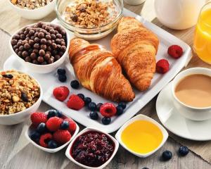 a breakfast table with croissantsberries berries and other breakfast foods at Hofer Hof Spieler in Lagundo +11 photos