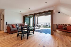 a living room with a table and chairs and a balcony at Hofer Hof Spieler in Lagundo