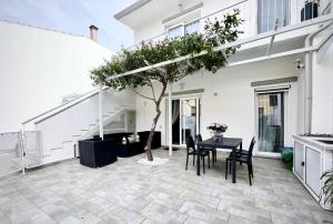 a patio with a table and chairs and a tree at La Casa dei sognatori in Villasimius