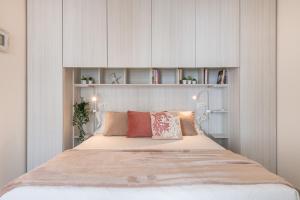a bedroom with a large bed with white cabinets at La Casa dei sognatori in Villasimius