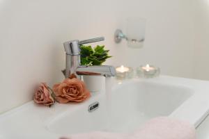 a bathroom sink with a faucet with a flower on it at La Casa dei sognatori in Villasimius +21 photos