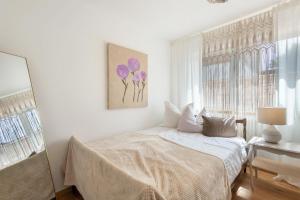 a white bedroom with a bed and a window at bei Thérèse - Große Wohnung Eg in Miltach