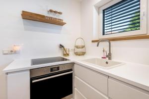 a white kitchen with a sink and a stove at bei Thérèse - Große Wohnung Eg in Miltach +24 photos