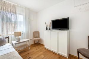 a living room with a flat screen tv on a white cabinet at bei Thérèse - Große Wohnung Eg in Miltach