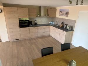 a kitchen with wooden cabinets and a table with chairs at Fewo Eckernförde mit Meerblick in Eckernförde