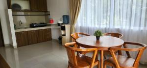 a kitchen with a wooden table and two chairs and a table at Grace Hill Villa Lubuk Minturun in Padang