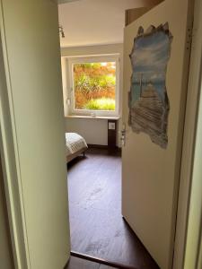 a room with a window and a door with a painting at Fewo Eckernförde mit Meerblick in Eckernförde