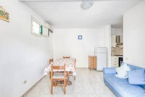 a living room with a table and a blue couch at Appartamento Luce sulla spiaggia in Torre San Giovanni Ugento