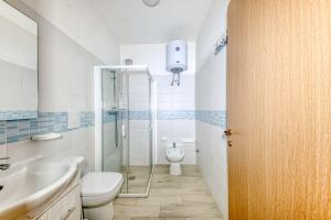 a bathroom with a shower and a toilet and a sink at Appartamento Luce sulla spiaggia in Torre San Giovanni Ugento +16 photos