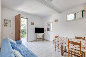 a living room with a blue couch and a tv at Appartamento Luce sulla spiaggia in Torre San Giovanni Ugento