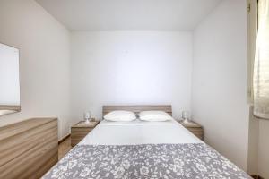 a bedroom with a bed and two night stands at Appartamento Luce sulla spiaggia in Torre San Giovanni Ugento