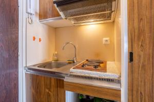 a kitchen with a sink in a tiny house at Studio vue mer - 50m de la plage in Bénodet