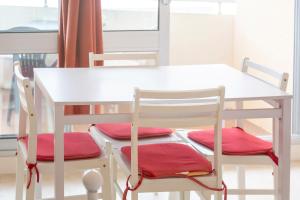 a white table and two chairs with red cushions at Studio vue mer - 50m de la plage in Bénodet +13 photos
