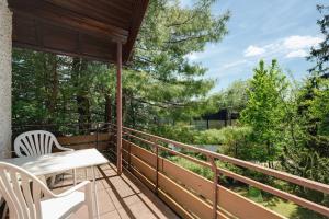 a balcony with a table and chairs and trees at Gästehaus Hirzel in Bad Wildbad