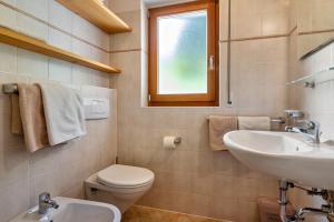 a bathroom with a sink and a toilet and a window at Kranebitterhof Apt Enzian in Valdaora