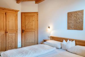 a bedroom with two beds and a wooden door at Kranebitterhof Apt Enzian in Valdaora