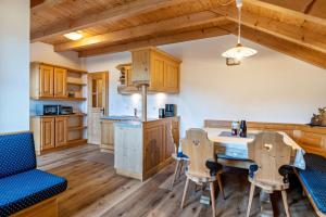 a kitchen with wooden cabinets and a table and chairs at Kranebitterhof Apt Enzian in Valdaora