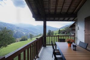 a balcony with a table and chairs and a view at Gîte La Clé Des Champs in Manigod
