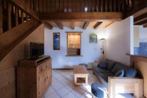 a living room with a couch and a tv at Gîte La Clé Des Champs in Manigod