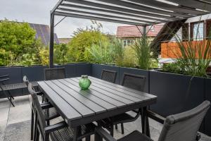 a green vase sitting on a wooden table on a patio at Fewo Ebringen Weinbergblick in Ebringen