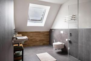 a bathroom with a toilet and a sink and a window at Fewo Ebringen Weinbergblick in Ebringen +24 photos