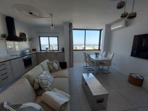 a living room with a couch and a table at Lindo T2 com vista mar in Quarteira