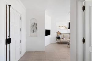 a hallway with white walls and a living room at Lindo T2 com vista mar in Quarteira