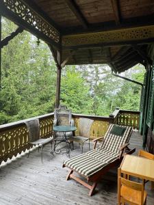 a screened in porch with chairs and a table at Haus Tanegg in Innsbruck