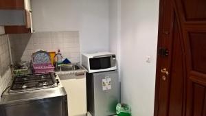 a kitchen with a microwave on top of a refrigerator at Résidence Ghozlane in Tunis