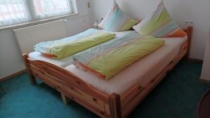 a wooden bed with two pillows on top of it at Ferienwohnung Stell in Altenbrak